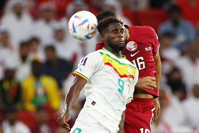 Pemain Senegal Boulaye Dia beraksi bersama pemain Qatar Boualem Khoukhi pada Piala Dunia FIFA Qatar 2022 di Stadion Al Thumama, Doha, Qatar, Jumat (25/11/2022). Foto: Bernadett Szabo/REUTERS