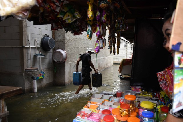 Warga mengangkut air saat banjir rob melanda kawasan pemukiman Muara Angke, Penjaringan, Jakarta Utara. Jumat (25/11/2022). Foto: Indrianto Eko Suwarso/ANTARA FOTO