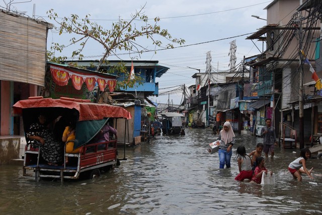 Sejumlah anak bermain saat banjir rob melanda kawasan pemukiman Muara Angke, Penjaringan, Jakarta Utara. Jumat (25/11/2022). Foto: Indrianto Eko Suwarso/ANTARA FOTO