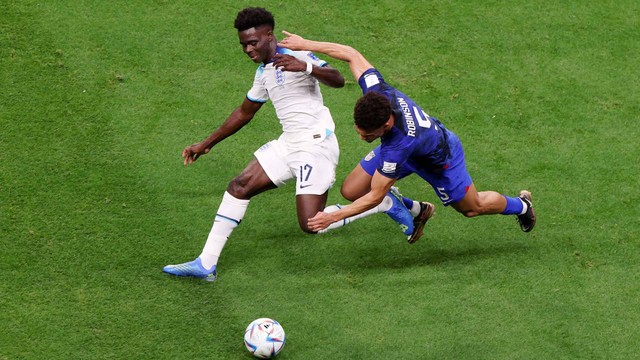 Bukayo Saka dari Inggris beraksi dengan Antonee Robinson dari A.S. di Piala Dunia FIFA Qatar 2022 di Stadion Al Bayt, Al Khor, Qatar, 25 November 2022. Foto: Molly Darlington/REUTERS