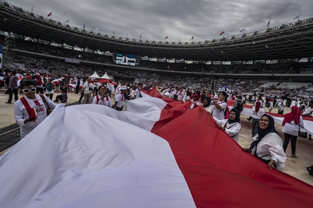 Sejumlah relawan membentangkan bendera Merah Putih dalam acara Gerakan Nusantara Bersatu : Satu Komando Untuk Indonesia di Stadion Utama Gelora Bung Karno, Jakarta, Sabtu (26/11/2022). Foto: Aprillio Akbar/Antara Foto