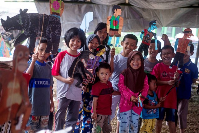 Sejumlah anak korban gempa bercerita dengan menggunakan wayang berkarakter hewan bersama Pendongeng keliling satwa langka Indonesia, Samsudin di Posko Pengungsian Sarampad, Kabupaten Cianjur, Jawa Barat, Sabtu (26/11/2022). Foto: Wahyu Putro A/ANTARA FOTO