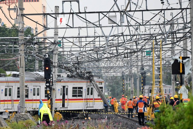 Sejumlah petugas berupaya mengevakuasi rangkaian kereta rel listrik (KRL) Commuterline KA 5144C yang anjlok dan tertimpa tiang listrik di perlintasan Stasiun Kampung Bandan, Jakarta, Sabtu (26/11/2022). Foto: Aditya Pradana Putra/ANTARA FOTO