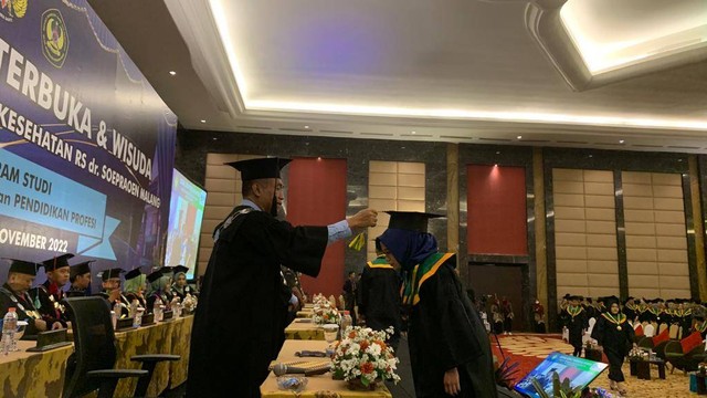 Rektor ITSK RS dr Soepraoen saat mengukuhkan salah seorang wisudawan. Foto / Feni Yusnia