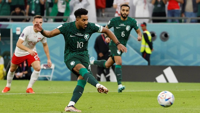 Pemain Arab Saudi Salem Al-Dawsari melakukan tendangan penalti ke gawang Polandia pada Piala Dunia 2022, di Education City Stadium, Al Rayyan, Qatar, sabtu (26/11/2022). Foto: Issei Kato/REUTERS