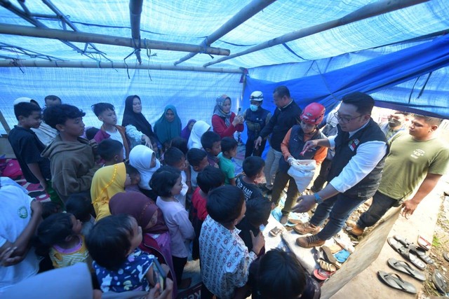 Gubernur Jawa Barat, Ridwan Kamil, saat membagikan makanan kepada anak-anak di tenda pengungsian warga terdampak gempa Garut. Foto: Humas Jabar