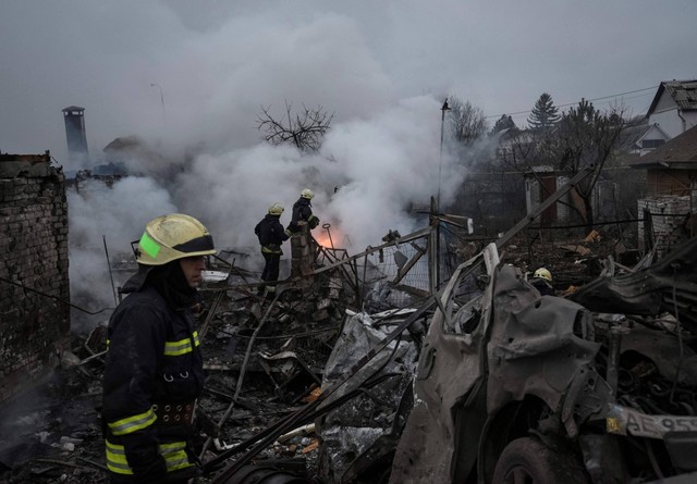 Petugas pemadam kebakaran bekerja di lokasi rumah pribadi yang terbakar di Dnipro, Ukraina, Sabtu (26/11/2022). Foto: Mykola Synelnykov/Reuters