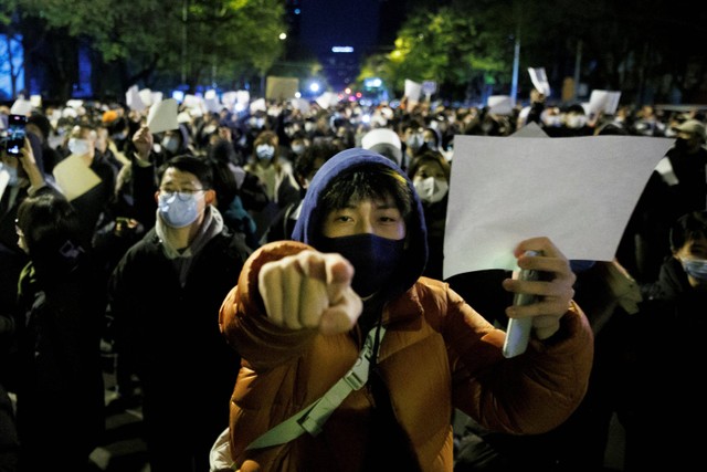 Sejumlah demonstran memegang kertas putih saat menggelar unjuk rasa pembatasan COVID-19 di Beijing, China. Foto: Thomas Peter/REUTERS