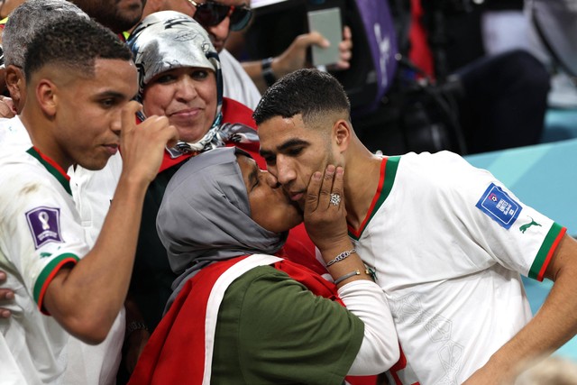 Bek Maroko, Achraf Hakimi disambut oleh ibunya di akhir pertandingan sepak bola Grup F Piala Dunia 2022, antara Belgia vs Maroko di Stadion Al-Thumama di Doha, Qatar, Minggu (27/11/2022). Foto: FADEL SENNA / AFP