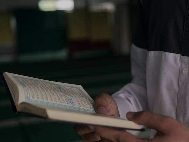 Ilustrasi seorang laki-laki membaca Al-Quran dengan makharijul huruf. Foto: Unsplash/Masjid Pogung Dalangan