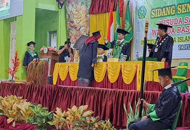 Tampak Rektor IAIN Sorong, Dr. Hamzah Khaeriyah, M.Ag tengah mewisudahkan mahasiswanya yang telah menyelesaikan akademi.