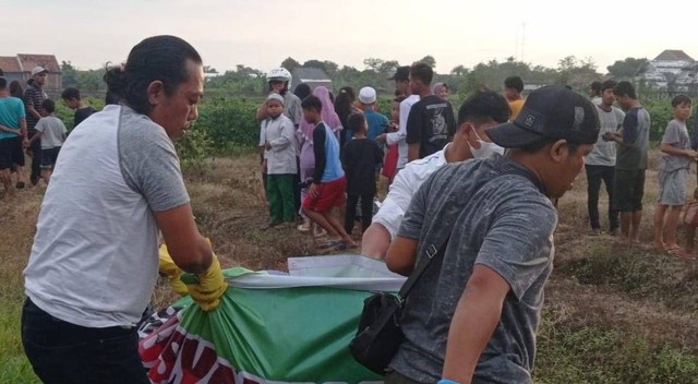 Anggota Polres Tegal mengevakuasi mayat yang hangus terbakar di Desa Kaliwadas Kecamatan Adiwerna, Kabupaten Tegal, Jawa Tengah, Senin (28/11/2022). (Foto : Panji P Adhi)