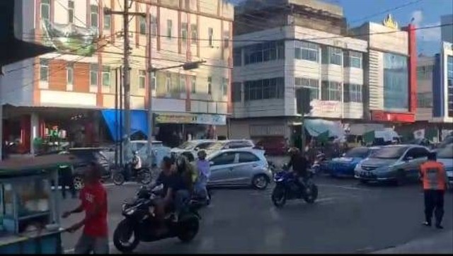 Pengendara sepeda motor di Kota Bandar Lampung tak menggunakan helm meskipun melewati polisi lalu lintas. | Foto: Lampung Geh