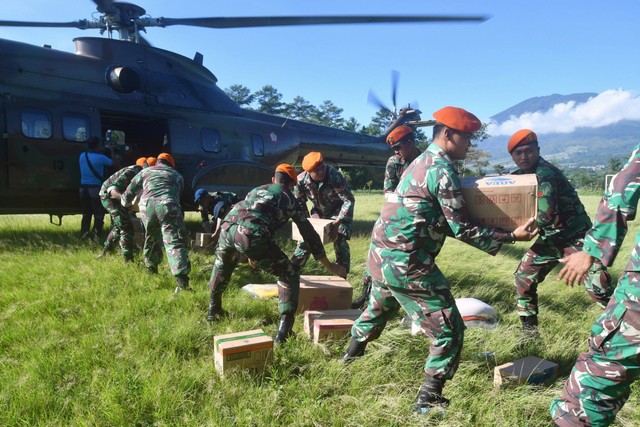 Sejumlah prajurit TNI AU menurunkan bantuan logistik untuk korban gempa bumi Cianjur dari helikopter Super Puma di Lapangan Aquila, Kabupaten Cianjur, Jawa Barat, Selasa (29/11/2022). Foto: Arif Firmansyah/Antara Foto