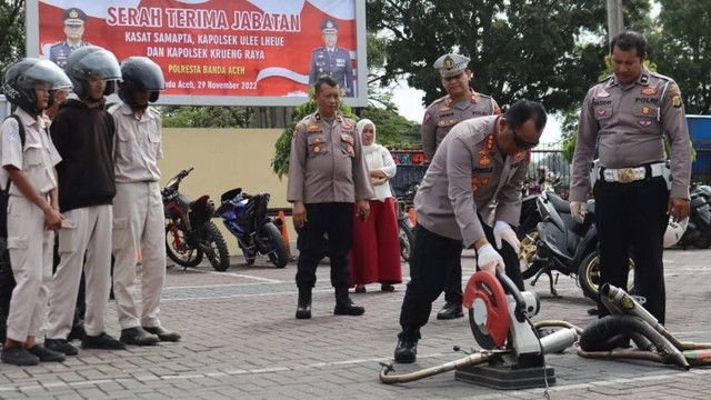 Kapolresta Banda Aceh Joko Krisdiyanto memotong knalpot bising/brong hasil penindakan di hadapan orang tua dan para pengendara sepeda motor, Selasa (29/11). Foto: Dok. Polresta