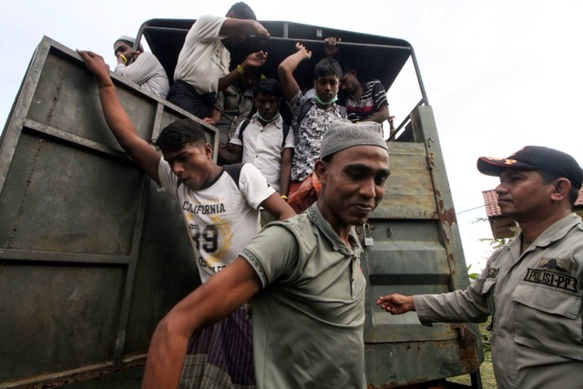 Sejumlah pengungsi etnis Rohingya turun dari truk saat dipindahkan ke lokasi bekas kantor Imigrasi Punteut di Desa Blang Mee, Kecamatan Blang Mangat, Lhokseumawe, Aceh, Selasa (29/11/2022). Foto: Rahmad/ANTARA FOTO