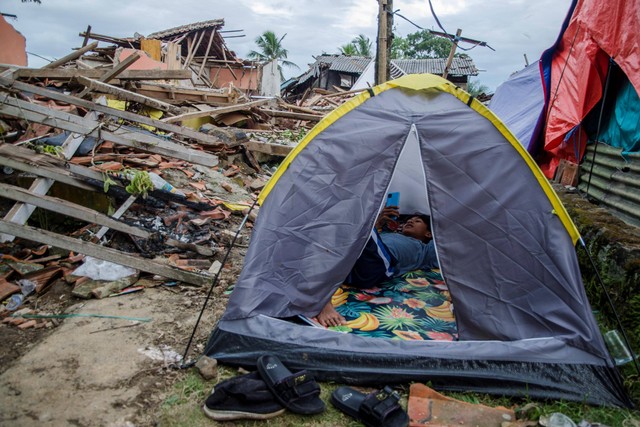 Warga beristirahat dalam tenda di sekitar reruntuhan rumah akibat gempa bumi di Gasol, Cianjur, Jawa Barat, Selasa (29/11/2022). Foto: Novrian Arbi/ANTARA FOTO