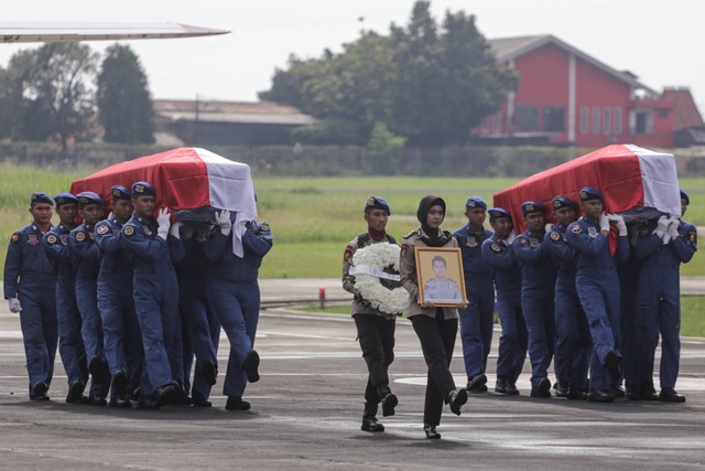 Sejumlah prajurit Polri mengusung peti jenazah CoPilot helikopter milik Polri NBO-105 Briptu M Lasminto dan peti jenazah mekanik helikopter milik Polri NBO-105 Bripda Khairul Anam saat upacara penyerahan jenazah di Lapangan Terbang Polisi Udara. Foto: Fauzan/Antara Foto