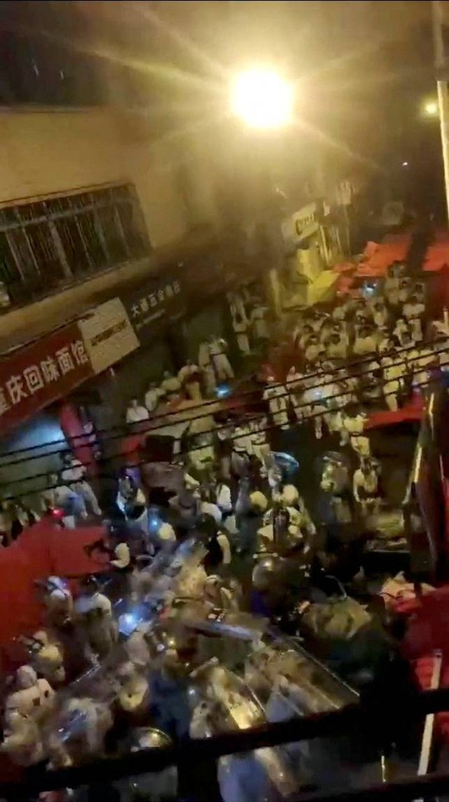 Polisi anti huru hara menggunakan APD saat protes menolak lockdown di Guangzhou, Guangdong, Tiongkok, Rabu (30/11/2022). Foto: Video Obtained by Reuters