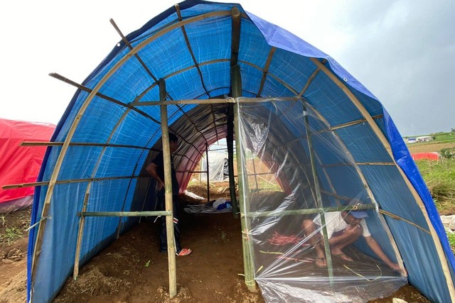 Warga membangun tenda pengungsian di tengah kebun,  di Kampung Sarongge Kidul, Desa Ciputri, Kecamatan Pacet, Cianjur, Rabu (30/11/2022). Foto: Muhammad Iqbal/kumparan