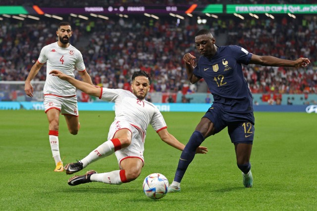 Pemain Timnas Prancis Solo Muani berusaha melewati pemain Timnas Tunisia Wajdi Kechrida pada pertandingan Grup D Piala Dunia 2022 Qatar di Education City Stadium, Al Rayyan, Qatar. Foto: Carl Recine/REUTERS