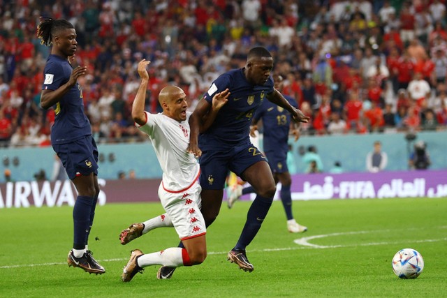 Pemain Timnas Prancis Ibrahima Konate berebut bola dengan pemain Timnas Tunisia Wahbi Khazri pada pertandingan Grup D Piala Dunia 2022 Qatar di Education City Stadium, Al Rayyan, Qatar. Foto: Hannah McKay/REUTERS