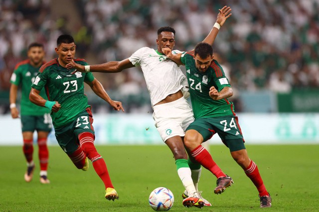 Pemain Timnas Arab Saudi Mohamed Kanno berebut bola dengan pemain Timnas Meksiko Luis Chavez pada pertandingan Grup C Piala Dunia 2022 Qatar di Stadion Lusail, Lusail, Qatar. Foto: Alberto Lingria/REUTERS