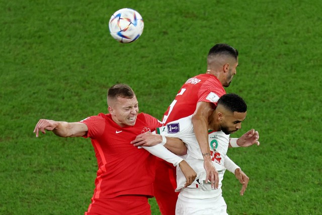 Pemain Kanada Steven Vitoria dan Alistair Johnston beraksi dengan pemain Maroko Youssef En-Nesyri pada Piala Dunia 2022, di Stadion Al Thumama, Doha, Qatar, Kamis (1/12/2022). Foto: Marko Djurica/REUTERS