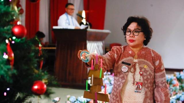 Kepala Dinas Pendidikan Daerah Provinsi Sulawesi Utara, dr Grace Punuh menyalakan lilin natal pada ibadah Pra Natal bersama Kepala Sekolah dan Guru.