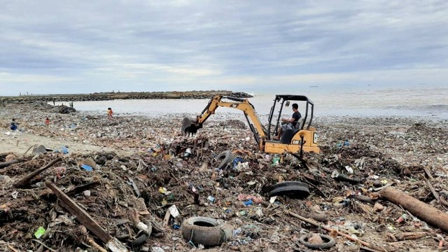 Petugas kebersihan membersihkan sampah di Pantai Padang, Sumatera Barat (Foto: Adi S/Langkan)