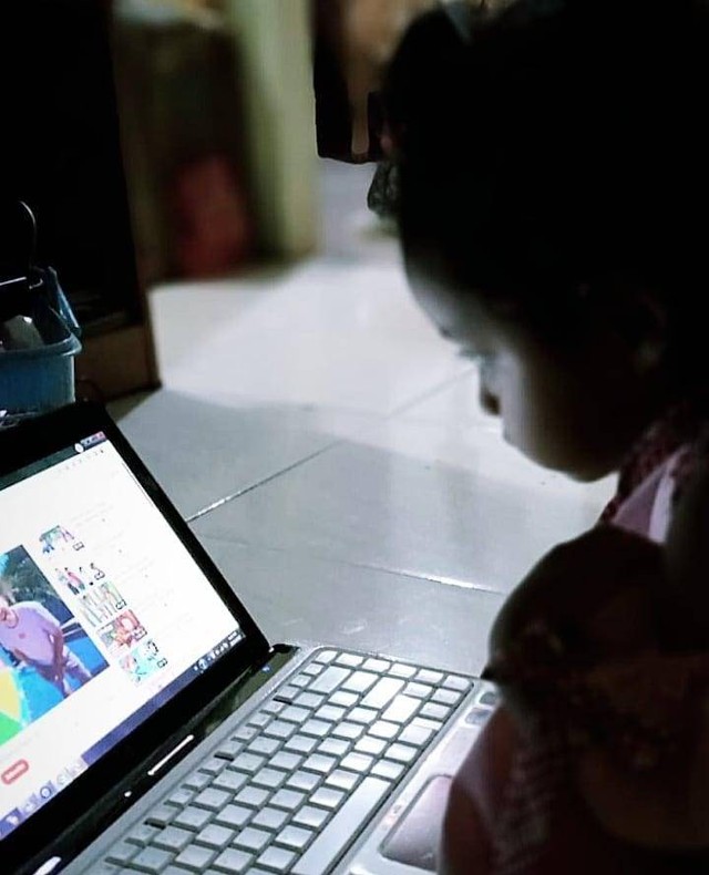 Foto seorang anak sedang menonton video-video YouTube di laptop, Jumat (02/12/2022). foto: Natasya Putri Nabilla 