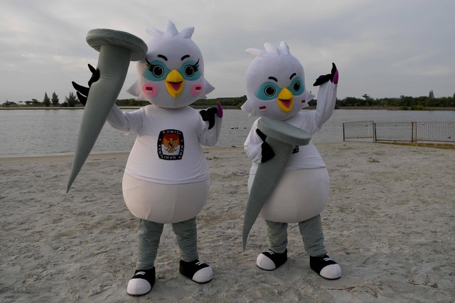 Warga dengan memakai kostum maskot Pemilu 2024 Sura dan Sulu berpose usai peluncurannya di Ancol, Jakarta Utara, Jumat (2/12/2022). Foto: Sigid Kurniawan/ANTARA FOTO