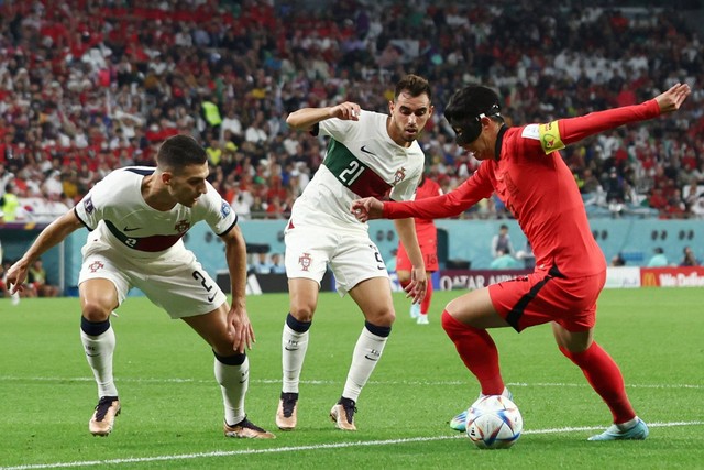 Pemain Timnas Portugal Ricardo Horta dan Diogo Dalot berusaha menghadang pemain Timnas Korea Selatan Son Heung-min pada pertandingan Grup H Piala Dunia 2022 Qatar di Education City Stadium, Al Rayyan, Qatar. Foto: Pedro Nunes/REUTERS