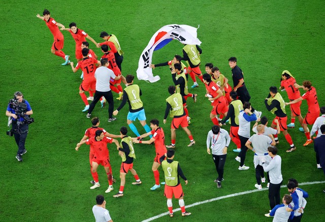 Anggota tim Korea Selatan berselebrasi setelah pertandingan saat Korea Selatan lolos ke babak sistem gugur Piala Dunia 2022, di Education City Stadium, Al Rayyan, Qatar, Jumat (2/12/2022). Foto: Fabrizio Bensch/REUTERS