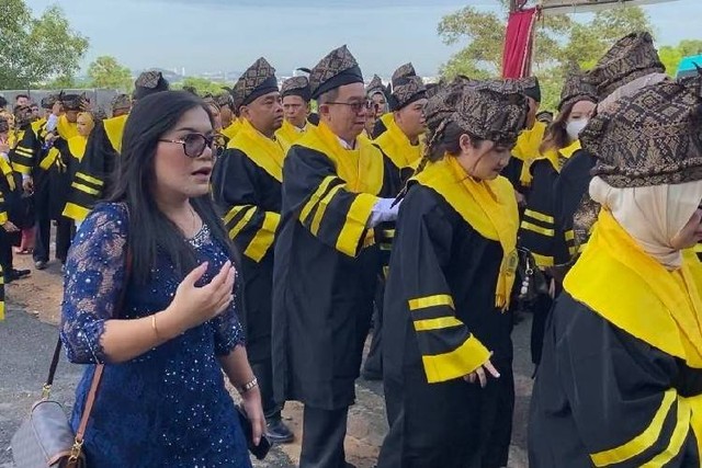 nggota DPRD Tanjungpinang, Ria Ukur Rindu Tondang (baju biru) terancam gagal wisuda sebagai magister di Universitas Batam. Ia tidak mendapatkan baju wisuda setelah ditahan pihak kampus.