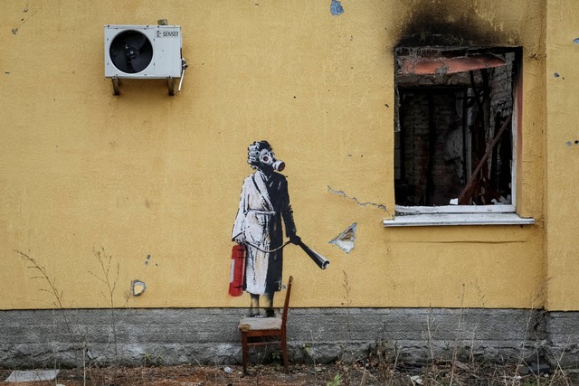Sebuah grafiti baru dengan gaya khas Banksy, terlihat di dinding sebuah bangunan yang hancur di kota Hostomel, Ukraina, pada 13 November 2022. Foto: Gleb Garanich/REUTERS