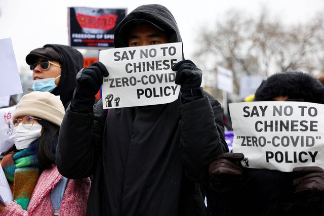 Demonstran memegang plakat selama protes terhadap pembatasan COVID-19 China, di Berlin, Jerman, Sabtu (3/12/2022). Foto: Christian Mang/REUTERS