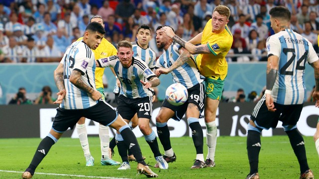 Pemain Australia Harry Souttar beraksi bersama pemain Argentina Alexis Mac Allister dan Nicolas Otamendi pada babak 16 besar Piala Dunia 2022 di Stadion Ahmad bin Ali, Al Rayyan, Qatar, Sabtu (2/12/2022). Foto: Kai Pfaffenbach/REUTERS