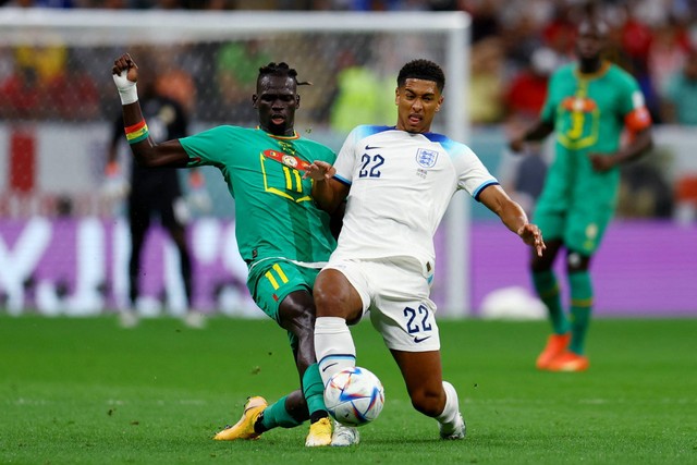 Pemain Senegal Pathe Ciss beraksi bersama pemain Inggris Jude Bellingham pada babak 16 besar Piala Dunia 2022, di Stadion Al Bayt, Al Khor, Qatar, Minggu (4/12/2022). Foto: Molly Darlington/REUTERS