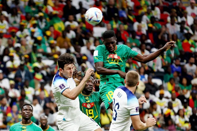 Pemain Senegal Ismaila Sarr beraksi bersama pemain Inggris Harry Maguire pada babak 16 besar Piala Dunia 2022, di Stadion Al Bayt, Al Khor, Qatar, Minggu (4/12/2022). Foto: Marko Djurica/REUTERS