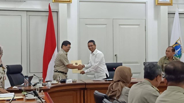 Pejabat Gubernur DKI Jakarta Heru Budi Hartono menyerahkan SK Deputi Gubernur kepada Marullah Matali, Senin (5/12/2022). Foto: Haya Syahira/kumparan
