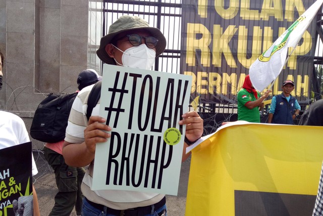 Massa membawa poster penolakan RKUHP dalam aksi demonstrasi di depan Gedung DPR/MPR, Jakarta, Senin (5/12/2022). Foto: Ananta Erlangga/kumparan