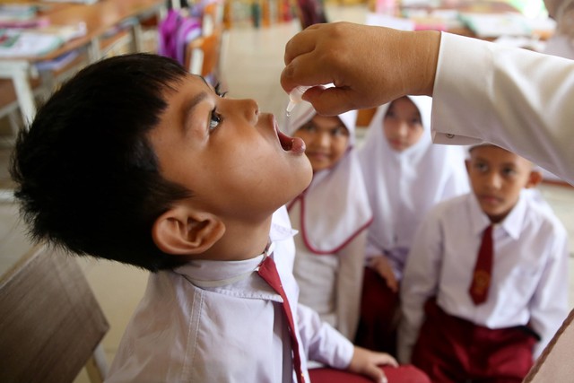 Petugas memberi vaksin polio kepada pelajar Sekolah Dasar (SD) Negeri 43 seusai pencanangan Sub Pekan Imunisasi Nasional (PIN) Polio oleh Menteri Kesehatan Budi Gunadi Sadikin di Banda Aceh, Aceh, Senin (5/12/2022). Foto: Irwansyah Putra/ANTARA FOTO