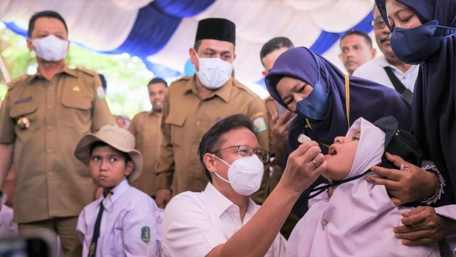 Menkes Budi Gunadi meneteskan vaksin polio kepada anak-anak di Anjong Mon Mata, Banda Aceh, Senin (5/12/2022). Foto: Abdul Hadi/acehkini