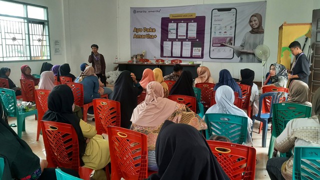 Petugas lapangan Amartha memberikan edukasi literasi digital bagi mitra UMKM Fintech Amartha di wilayah Payakumbuh, Sumatera Barat (2/12).