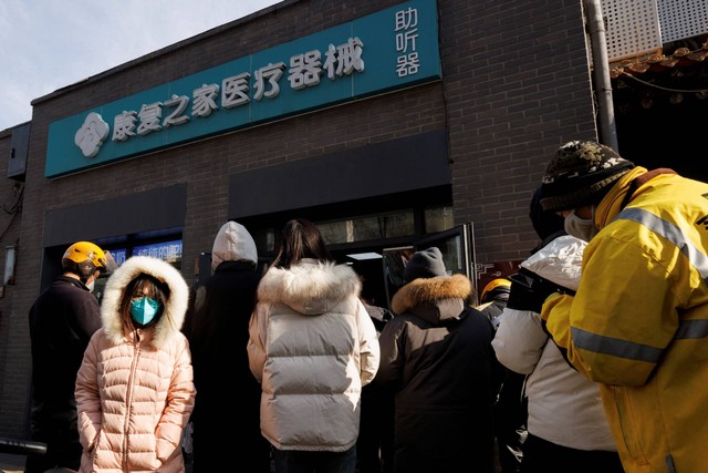 Orang-orang mengantre di apotek untuk membeli obat sata wabah COVID-19 berlanjut, di Beijing, China, Selasa (6/12/2022). Foto: Thomas Peter/REUTERS