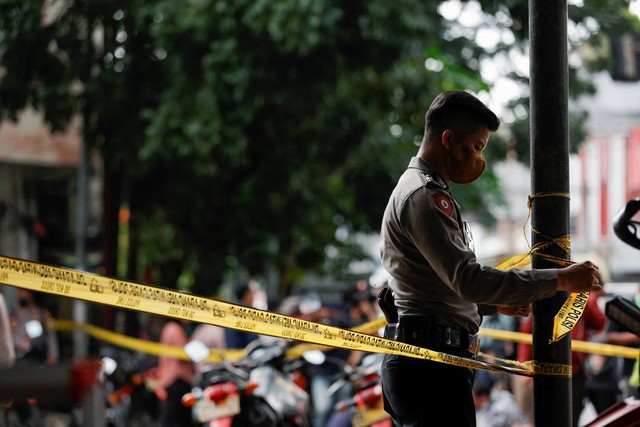 Polisi memasang garis polisi saat olah TKP bom bunuh diri di kawasan Astana Anyar, Bandung, Jawa Barat, usai ledakan bom bunuh diri, Rabu (7/12/2022). Foto: Willy Kurniawan/REUTERS