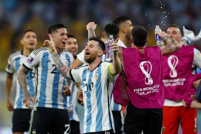 Pemain Argentina Lionel Messi bersama rekan setimnya merayakan kemenangannya dan lolos ke perempat final Piala Dunia 2022 di Stadion Ahmad bin Ali, Al Rayyan, Qatar, Sabtu (2/12/2022). Foto: Kai Pfaffenbach/REUTERS
