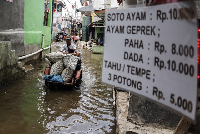 Pengendara becak motor melintasi banjir rob di Muara Angke, Jakarta, Rabu (7/12/2022). Foto: Darryl Ramadhan/Antara Foto