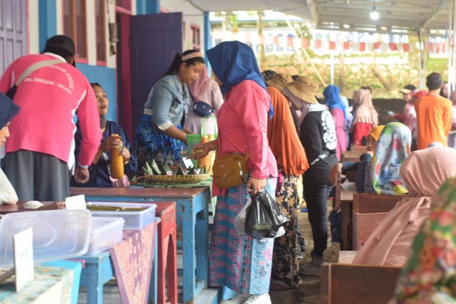 Seorang Ibu sedang membeli jajanan tradisional pada "Festival Dolanan dan Jajanan Tradisional" dusun Dokosari, Minggu (13/11/2022).
